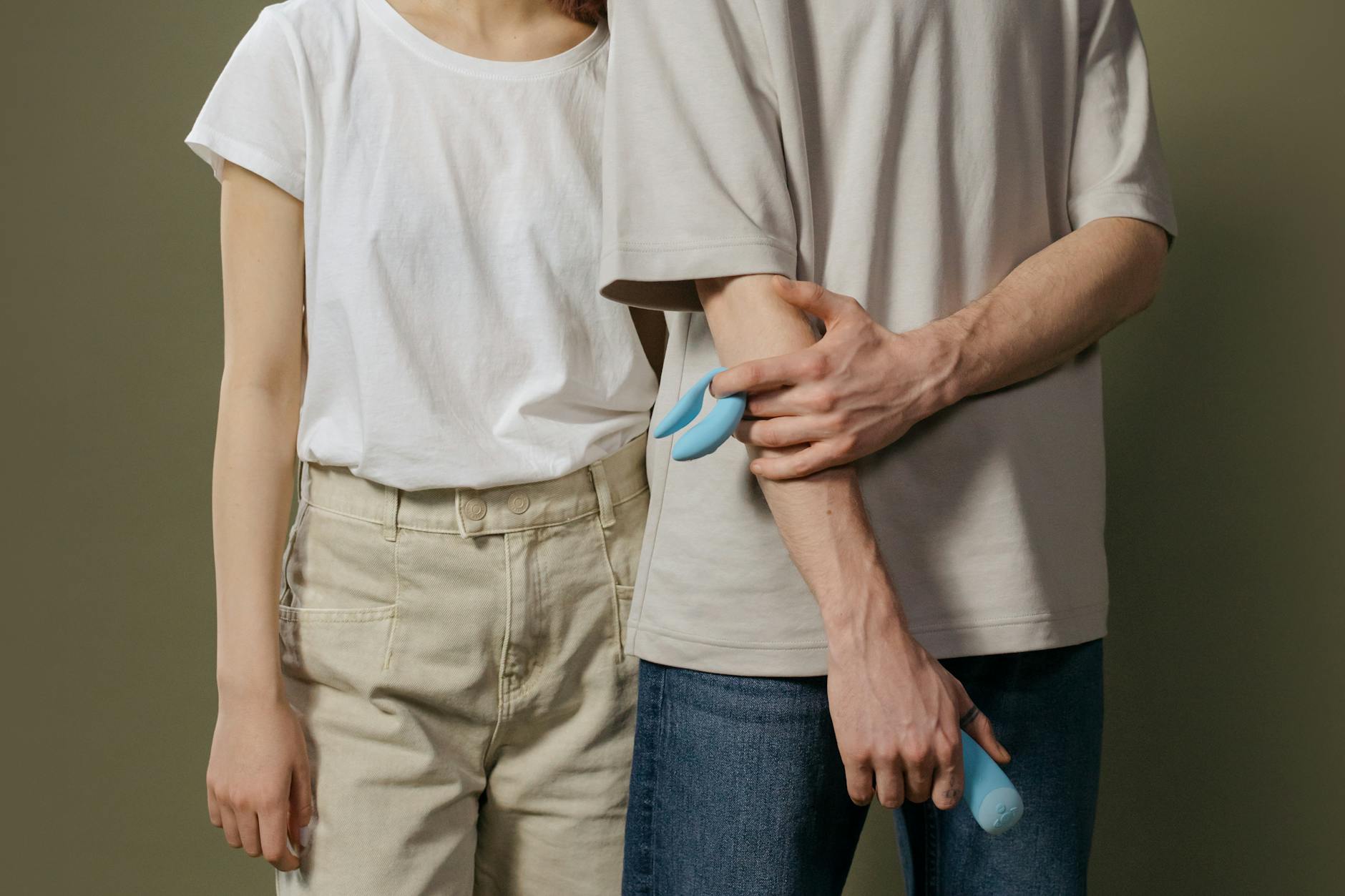 Close-up of hands holding a sleek blue lemon vibrator against a purple background, symbolizing intimate reconnection