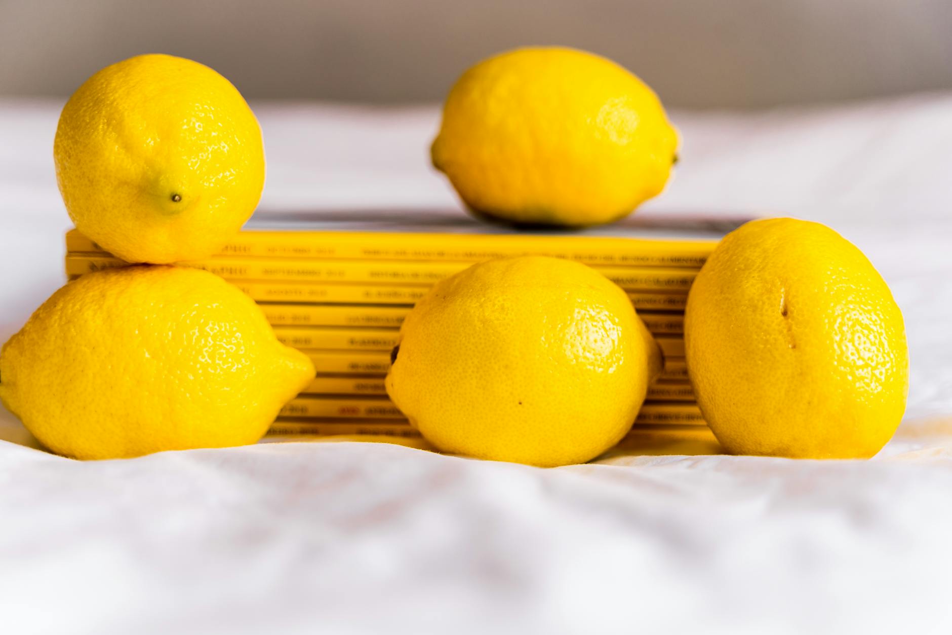 Citrons jaunes frais empilés avec des livres, représentant la fraîcheur et la sensibilité